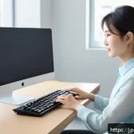손목 통증을 줄이는 생활 습관 - A young Japanese office worker sitting at a clean, modern desk in a bright room with natural sunligh...